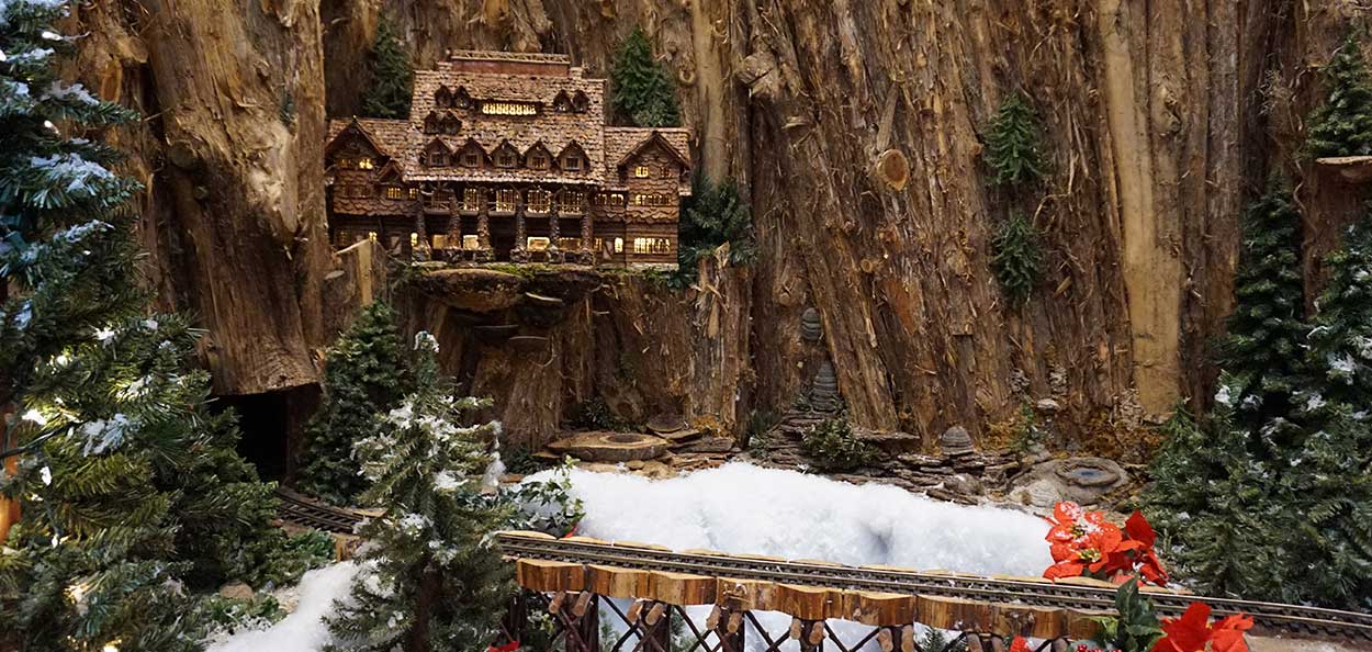 Miniature of a lodge in the mountains by a train track at the Eiteljorg Jingle Rails Exhibit