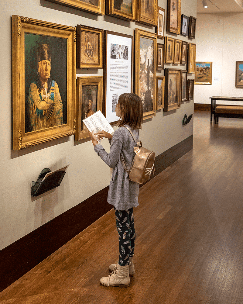 a child reading the museum guide in the Western Art Galleries