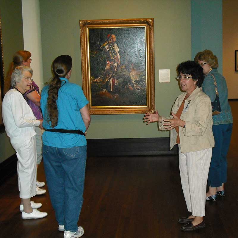 an Eiteljorg volunteer talks with museum visitors