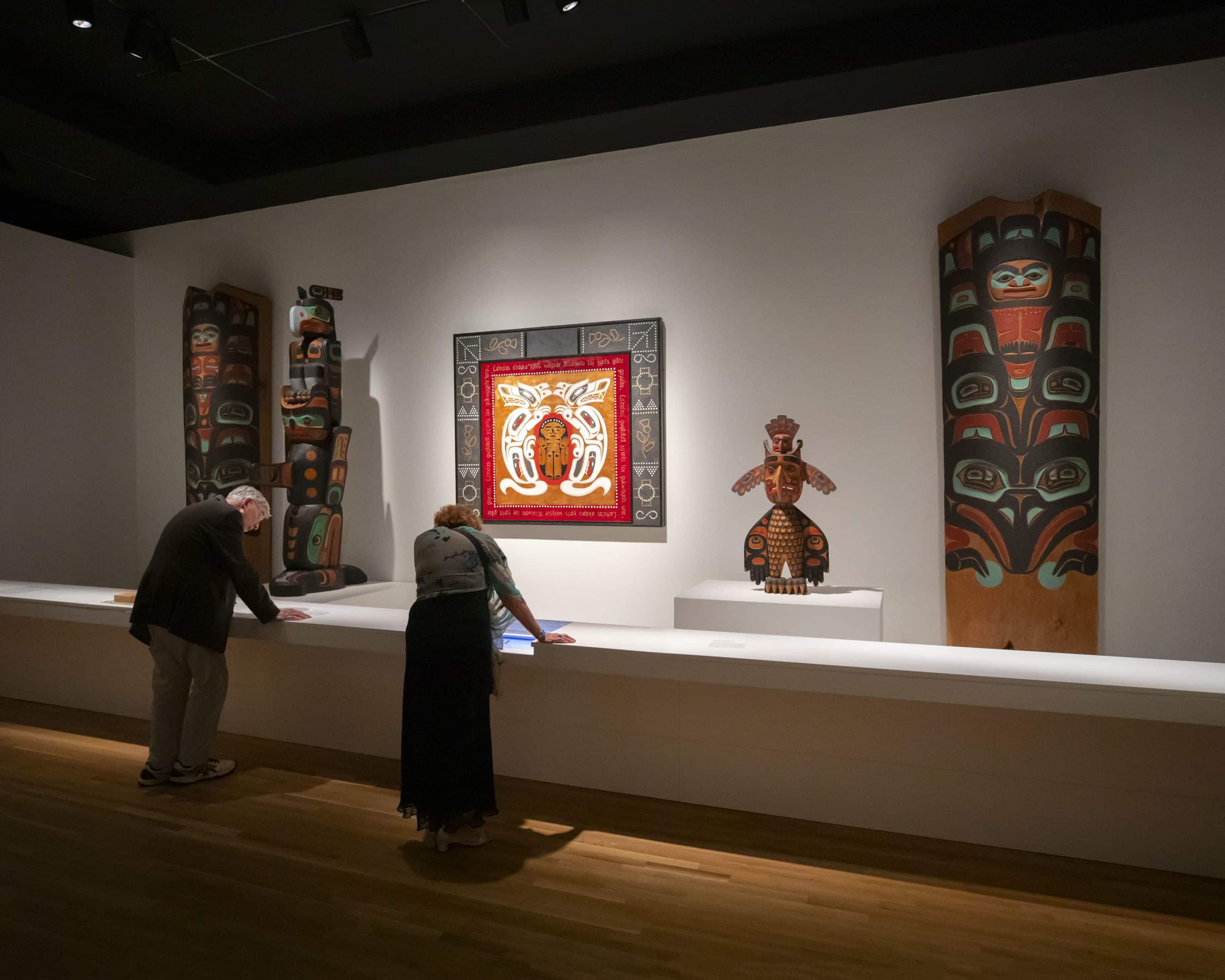 A woman observes an exhibit of Native clothing at the museum